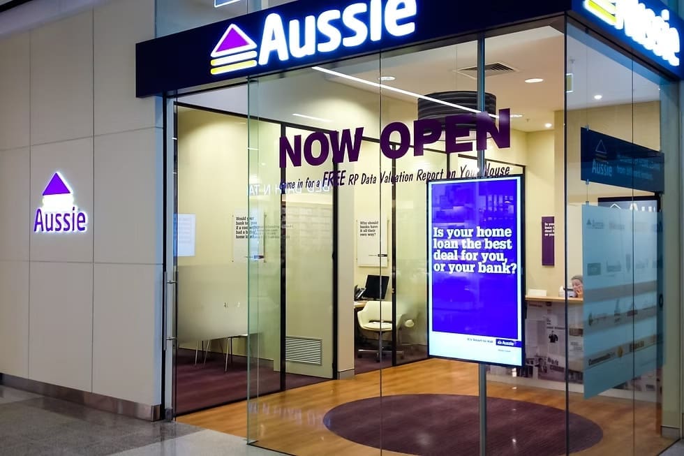 Aussie Home Loans storefront with glass entrance and digital signage promoting home loan services.