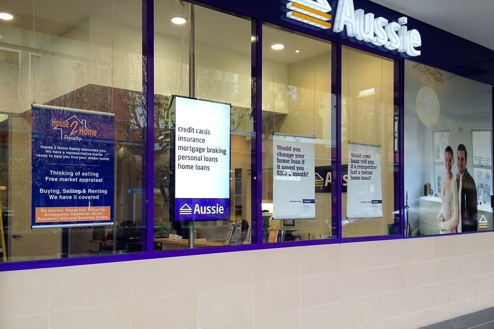 Aussie Home Loans storefront with promotional signage displaying services like home loans, credit cards, and insurance.