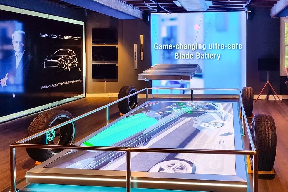 BYD showroom display featuring LED screens and an exhibit on the ultra-safe Blade Battery technology.