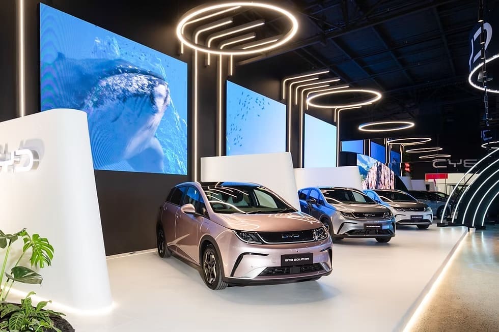 BYD Megastore showroom featuring electric vehicles with illuminated LED walls and circular ceiling lights.