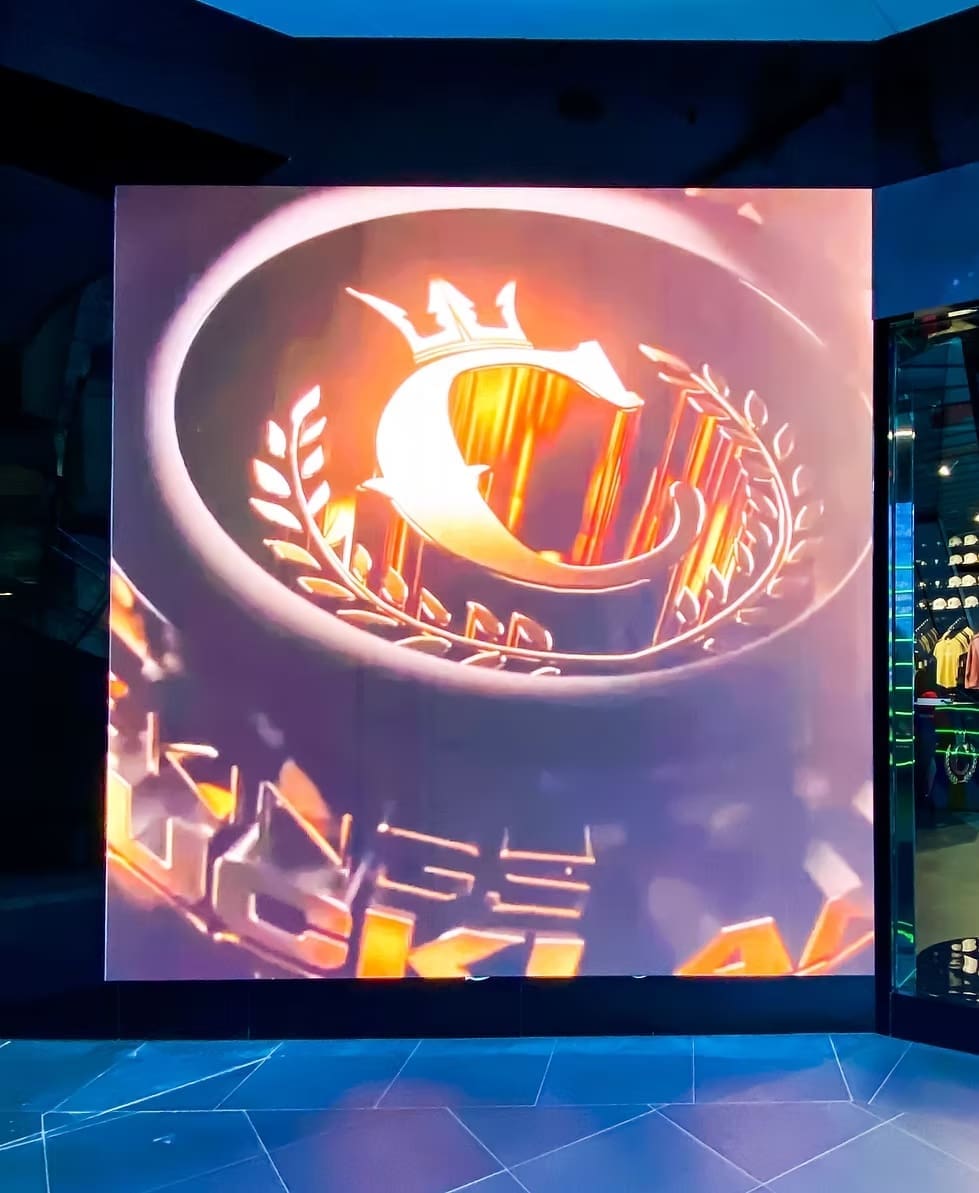 Large vertical LED display inside Culture Kings store showing illuminated brand logo visuals.