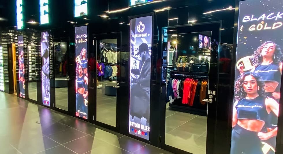 Culture Kings retail store interior with vertical LED panels featuring fashion and music-inspired digital displays.