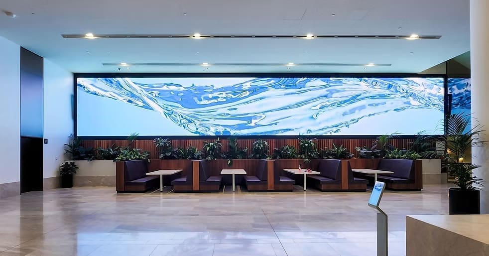 Wide LED wall display at MOBO Rooftop restaurant featuring flowing water visuals above modern indoor seating.