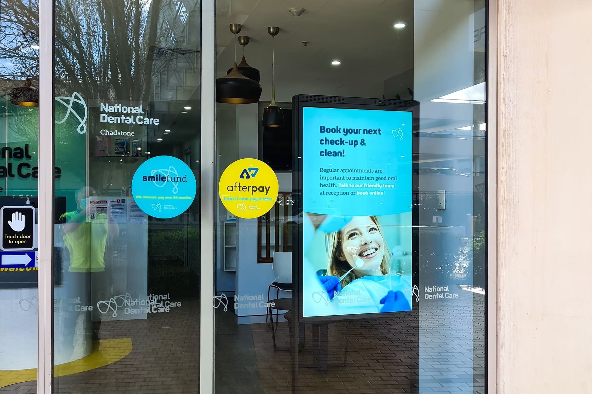 Digital LED display outside National Dental Care Chadstone promoting dental check-ups and Afterpay services.