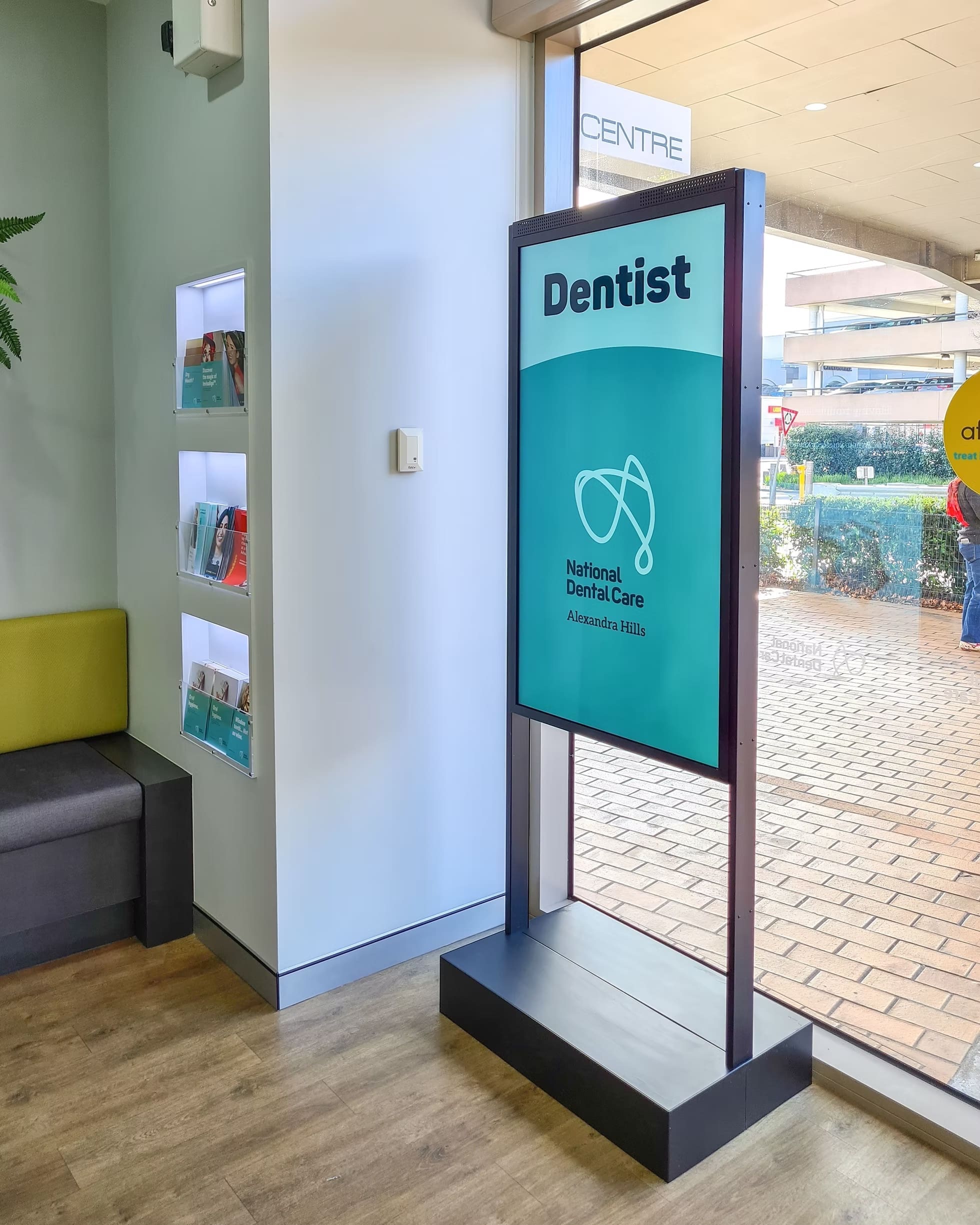 Indoor LED sign at National Dental Care Alexandra Hills showing the clinic’s logo and “Dentist” text.