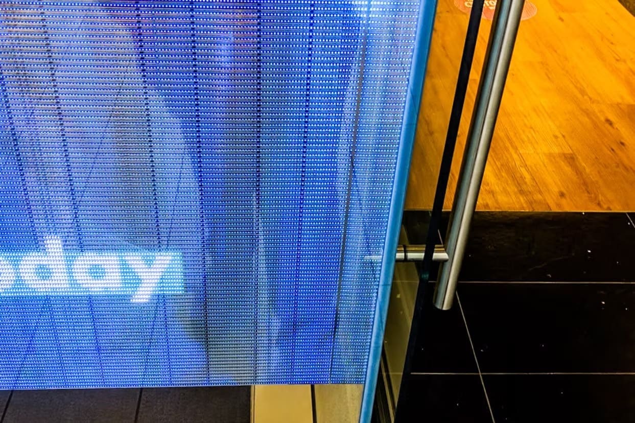 Close-up of LED panel at Optus store showing fine pixel pitch and screen detail near the glass edge.