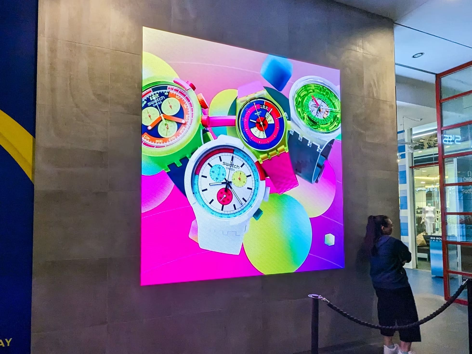Swatch Sydney store with a vivid LED display of colourful watches mounted on an exterior wall.