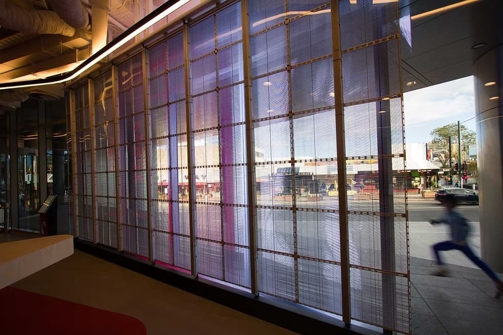 Close-up of transparent LED screen displaying the word “UNLIMITED” on a red background at Western Sydney University.